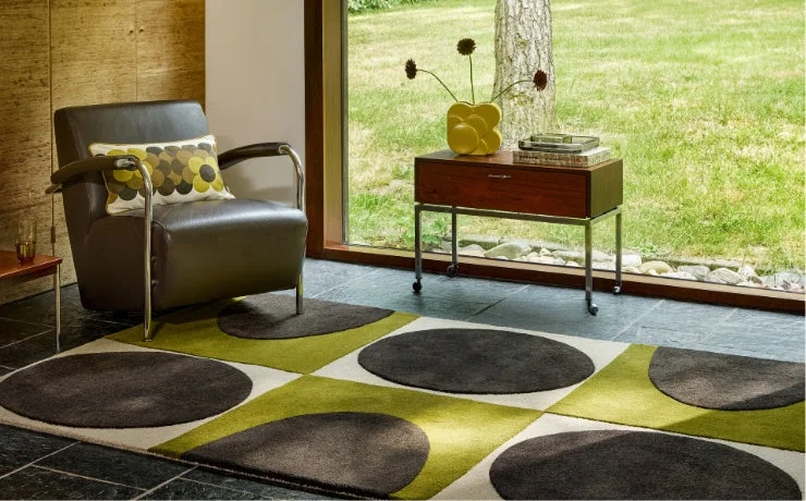 Orla Kiely rug in green and grey circles in a room with a leather armchair