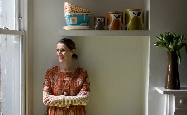 Orla Kiely in front of a shelf of ceramics