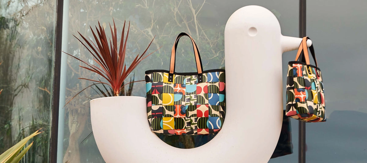 Orla Kiely Woven Waste basket bags beside a white bird-shaped vase